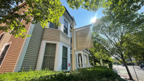 Front of 1727 Cambridge Street office building with a ray of sunlight coming through the trees.